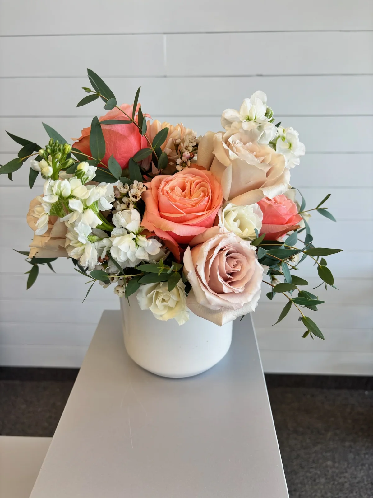 Peach blush and ivory sympathy arrangement in a white vase by a Hilliard Ohio florist